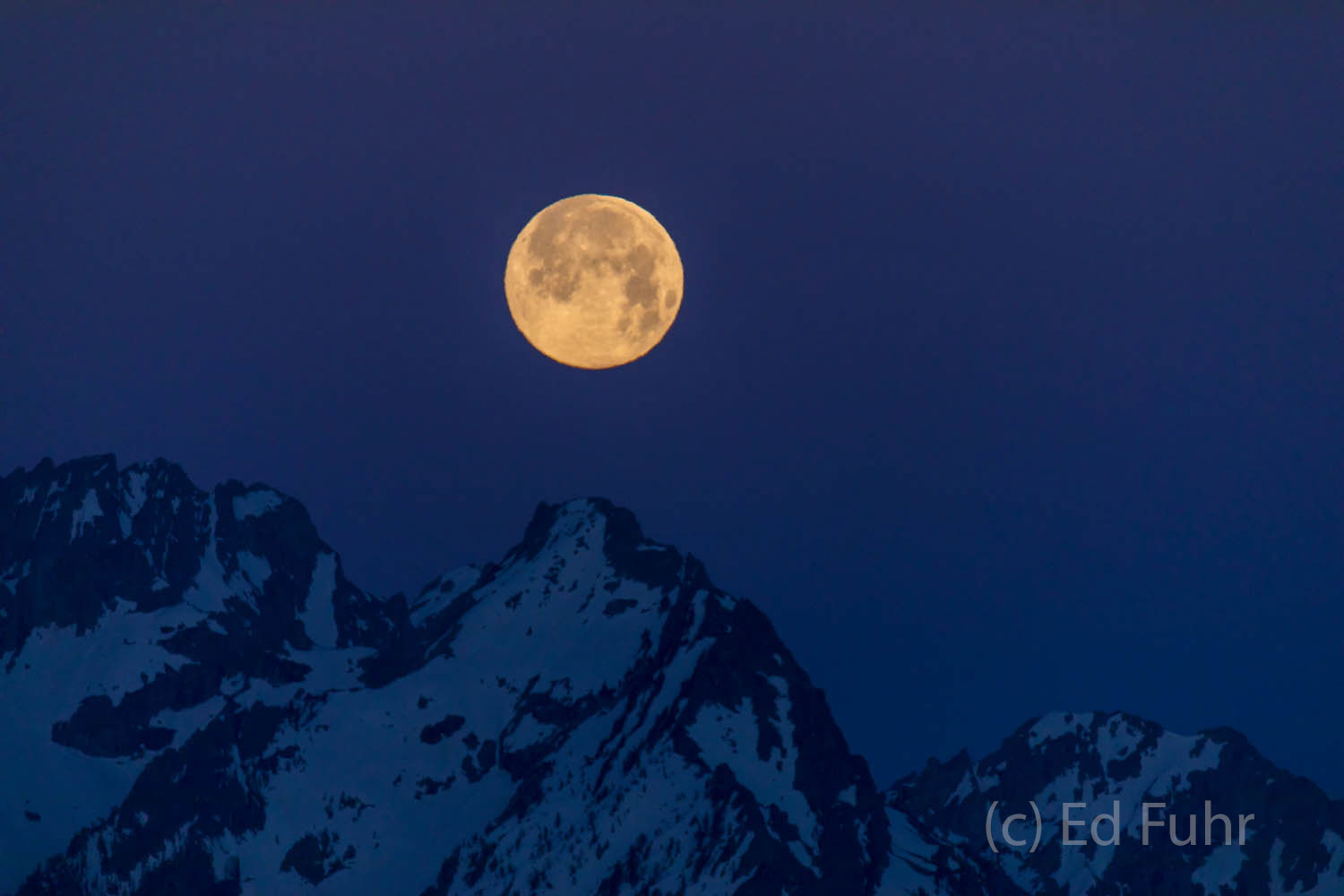 Before dawn, a blue moon prepares to set over the Tetons.  There is just a hint of light in the sky, dawn is still an hour away...