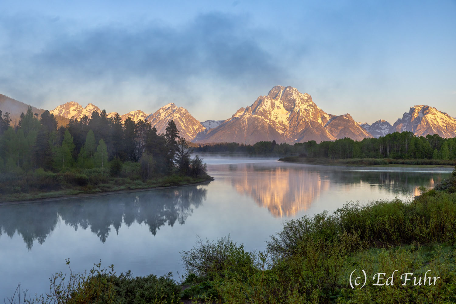 Wisps of fog lift above the slow-moving waters at Oxbow Bend.