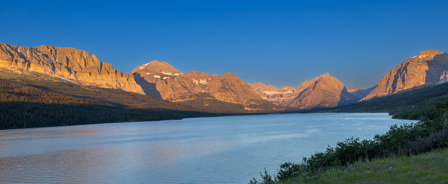 Sunrise brings an early glow to the mountains of Many Glacier that surround Lake Sherburne.