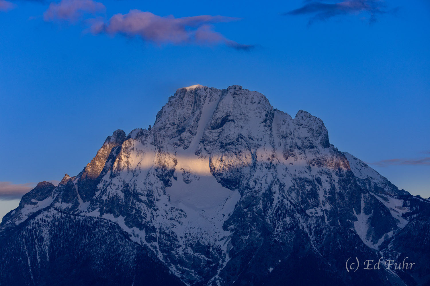 A moment of light finds the upper elevations of Mount Moran.