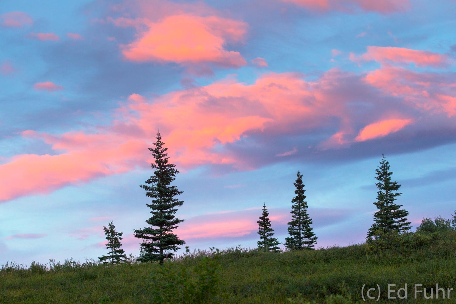 A final splash of color on the evening sky above a modest ridge.