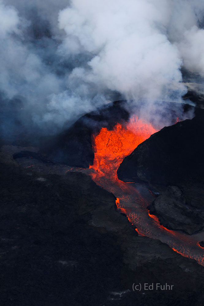 Molten lava pours out of the most active fissure where it will course for miles to the shore.