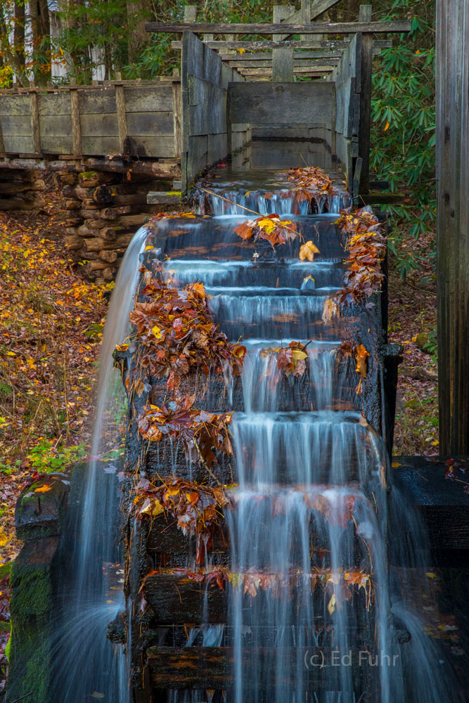 Autumn leaves cling to the large wheel that turns the mill from which flour has been ground for a generations in Cades Cove.