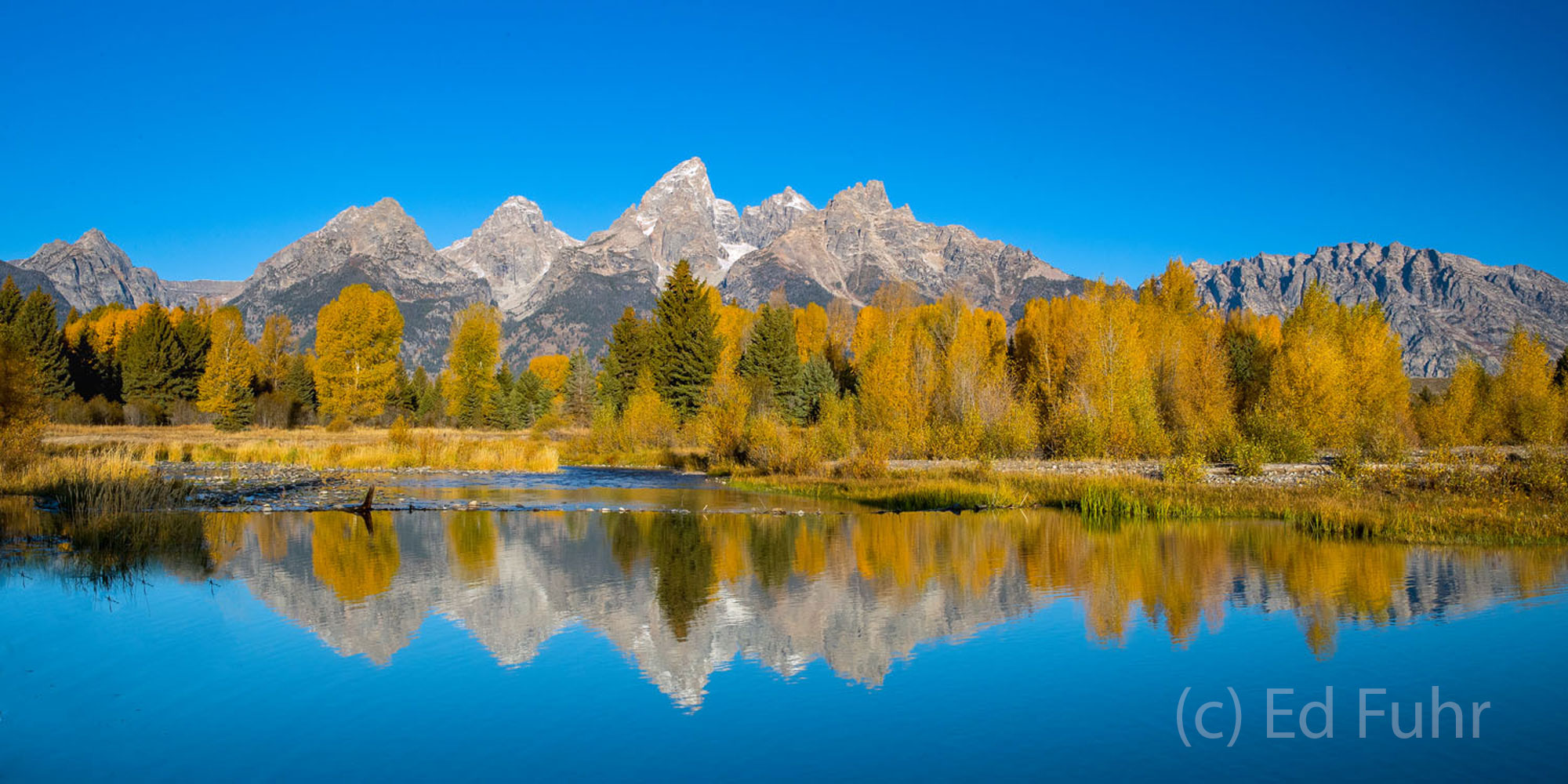 A Quiet Time at Schwabacher's At noon the winds that sweep along the river bottoms have grown still allowing the aspen and Teton mountain range to reflect...