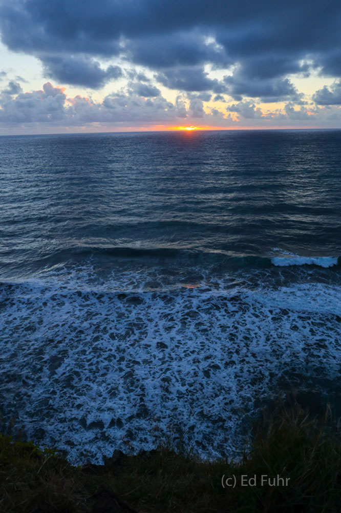 From the black sand beach of Pololu Valley, the sun first slips above the horizon.