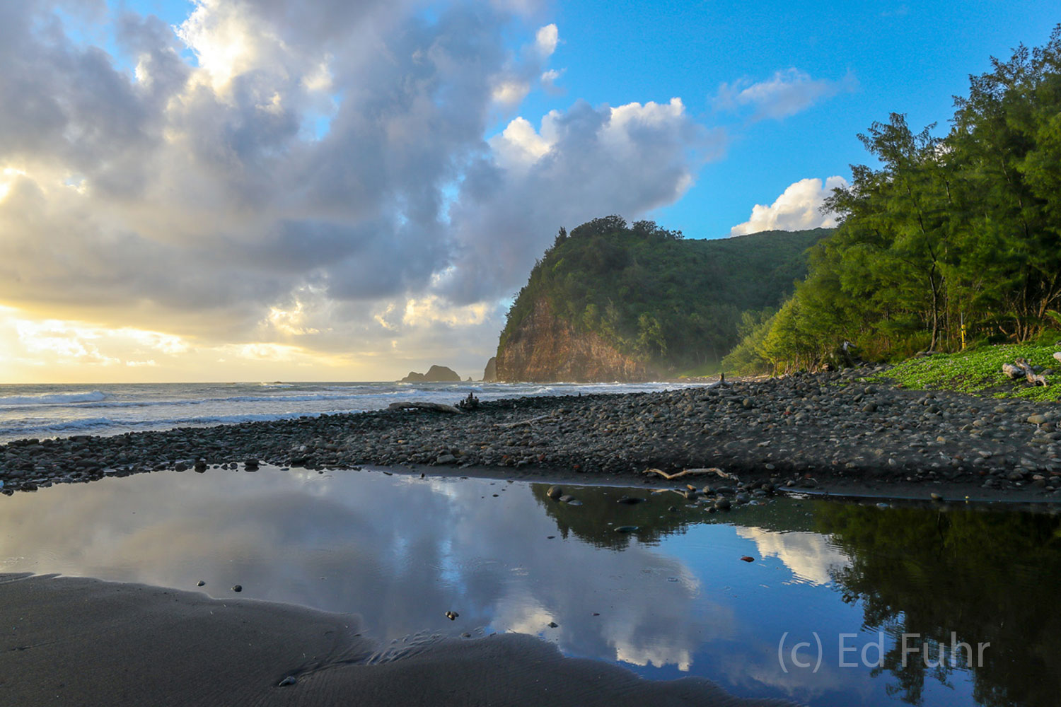 A small tidal pool reflects the early light in the Pololu Valley.