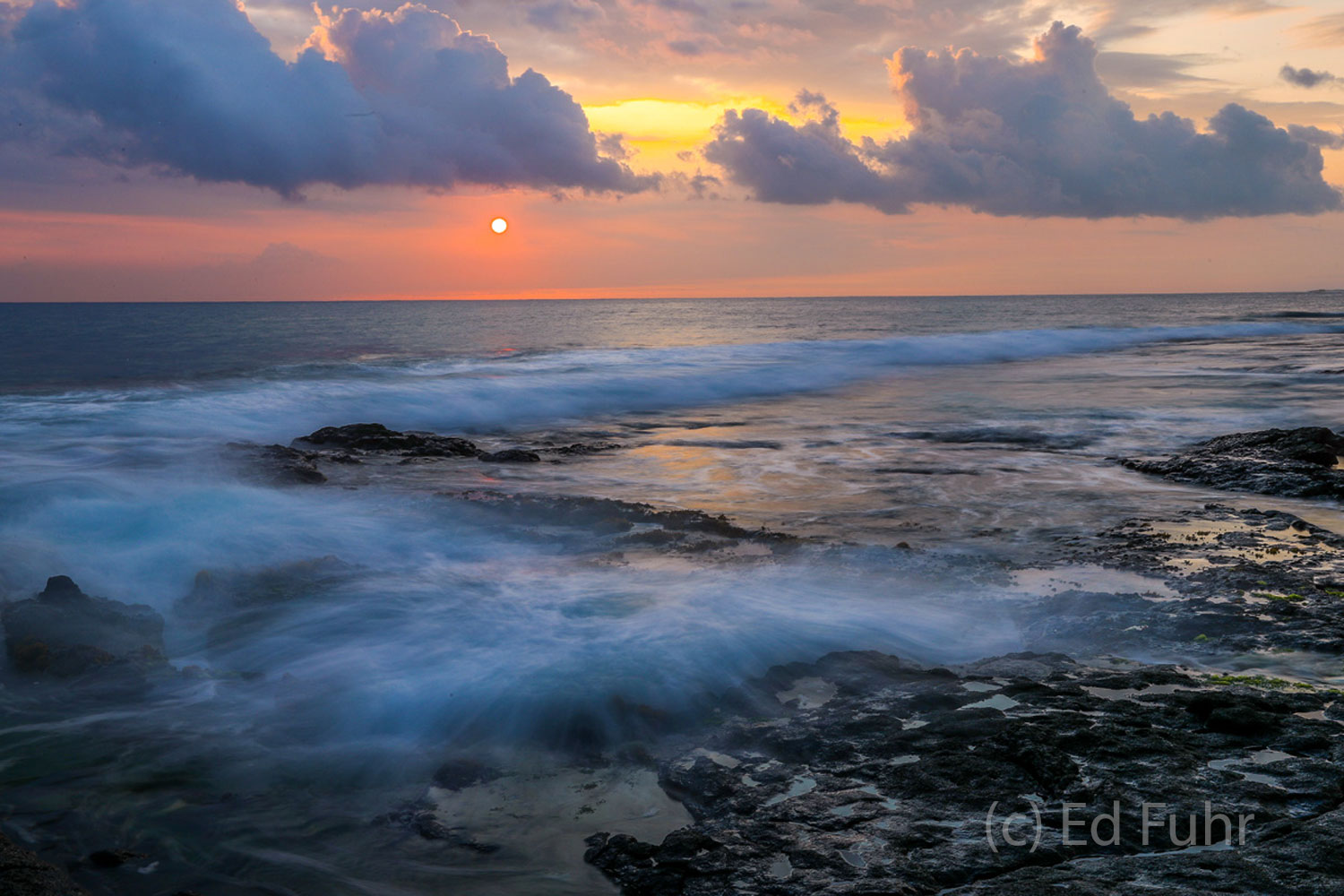 At dusk, this area near the lava tube reflects the beautiful skies, as the waters swirl across the lava shore.