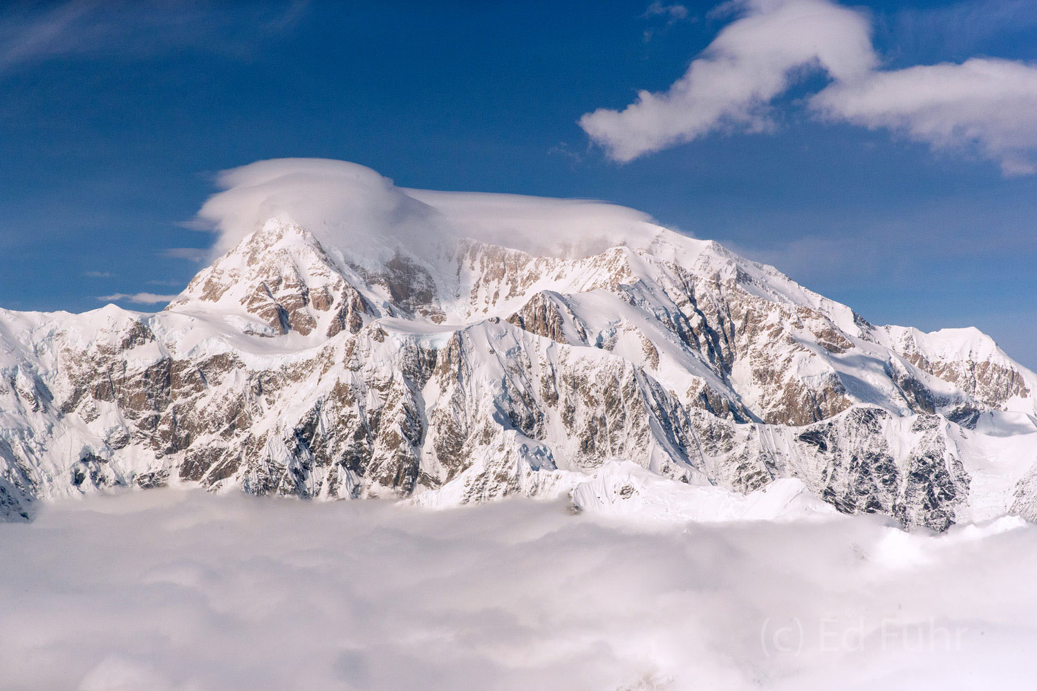 The western face of Denali rises above the clouds in the late afternoon