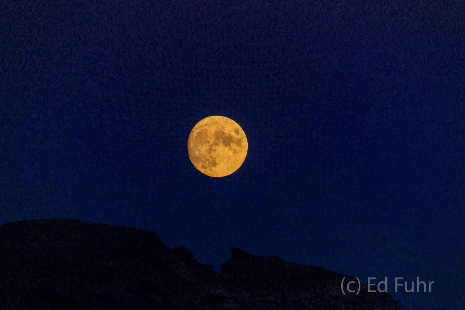 A full moon rises just above the silhouetted peak of Sleeping Indian. For what seems like years, I would read this book -- perhaps...