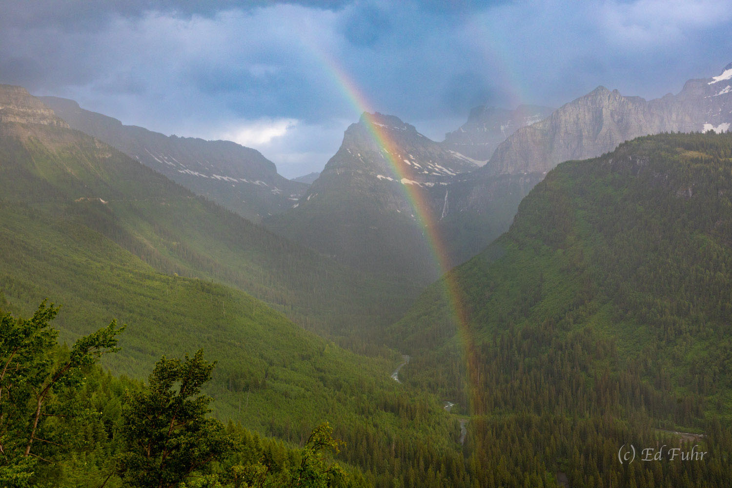 A rainbow emerges above Bird Woman Falls after a quick summer storm.