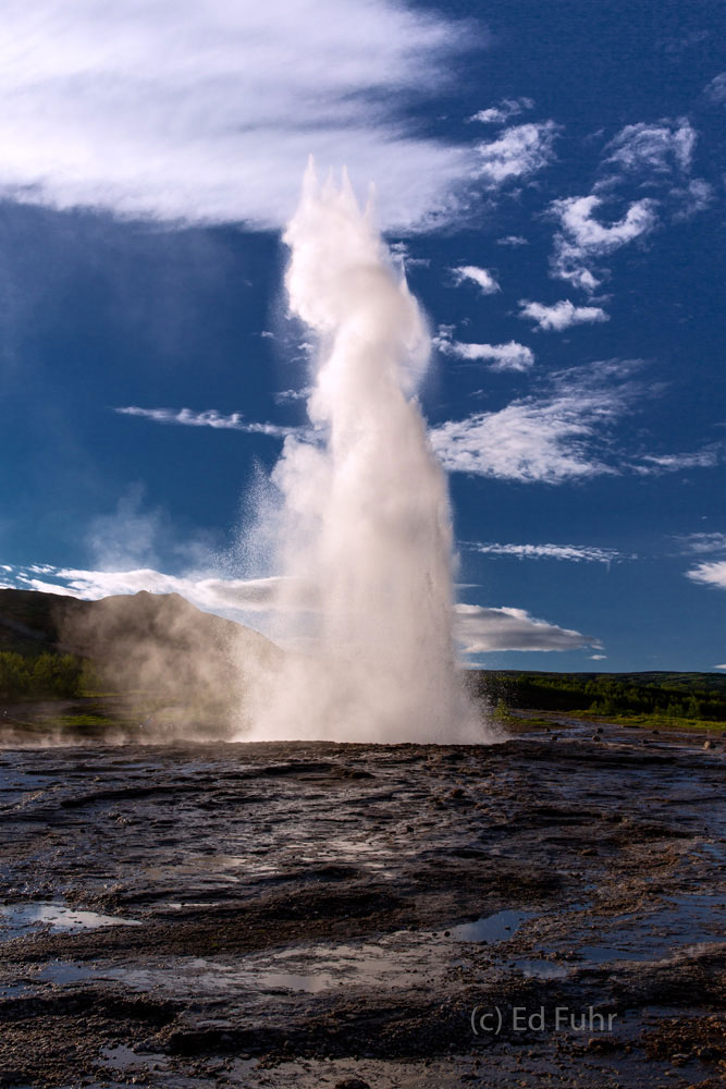 Strokkur Geysir Sunset Near sunset, Iceland's most famous geyser erupts into the cold blue sky. Strokkur is a fountain geyser that erupts every few...