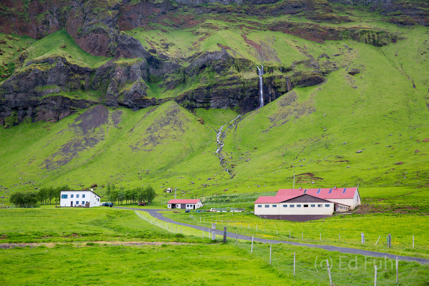 A Peaceful Place to Call Home A homestead below an unidentified waterfall, located between its famous sister falls, Skogafoss and Selljalandsfos.