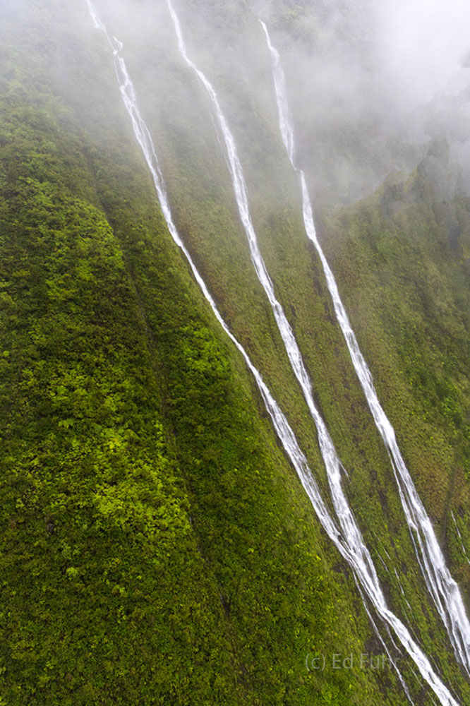 Waterfall Ribbons glisten against the lush green Kauai mountainsides.