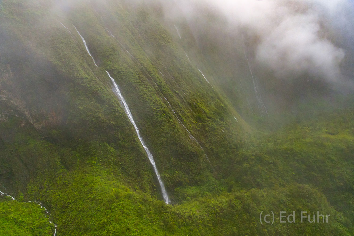 Yet another storm lifts above waterfalls tumbling into Kauai's valleys.