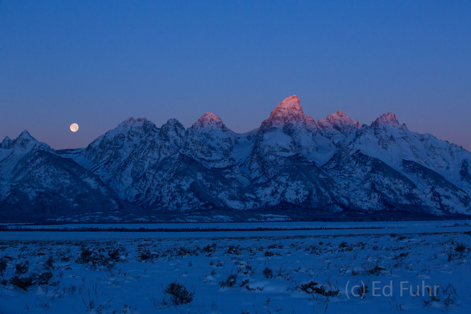 The very tip of the Grand Teton catches the first ray of winter light.