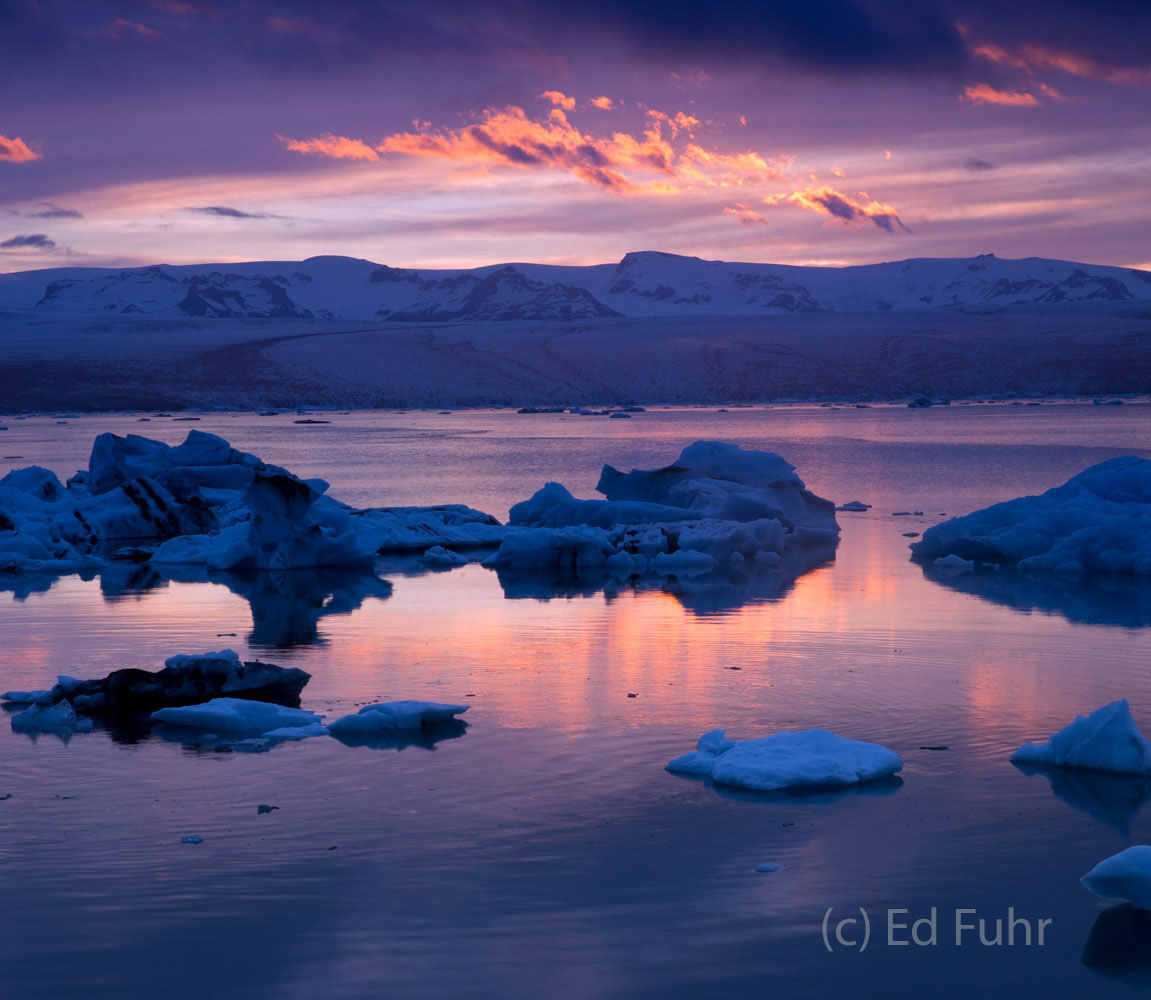From a nearby ridge, an amazing sunset unfolds over the lagoon and its blue icebergs.