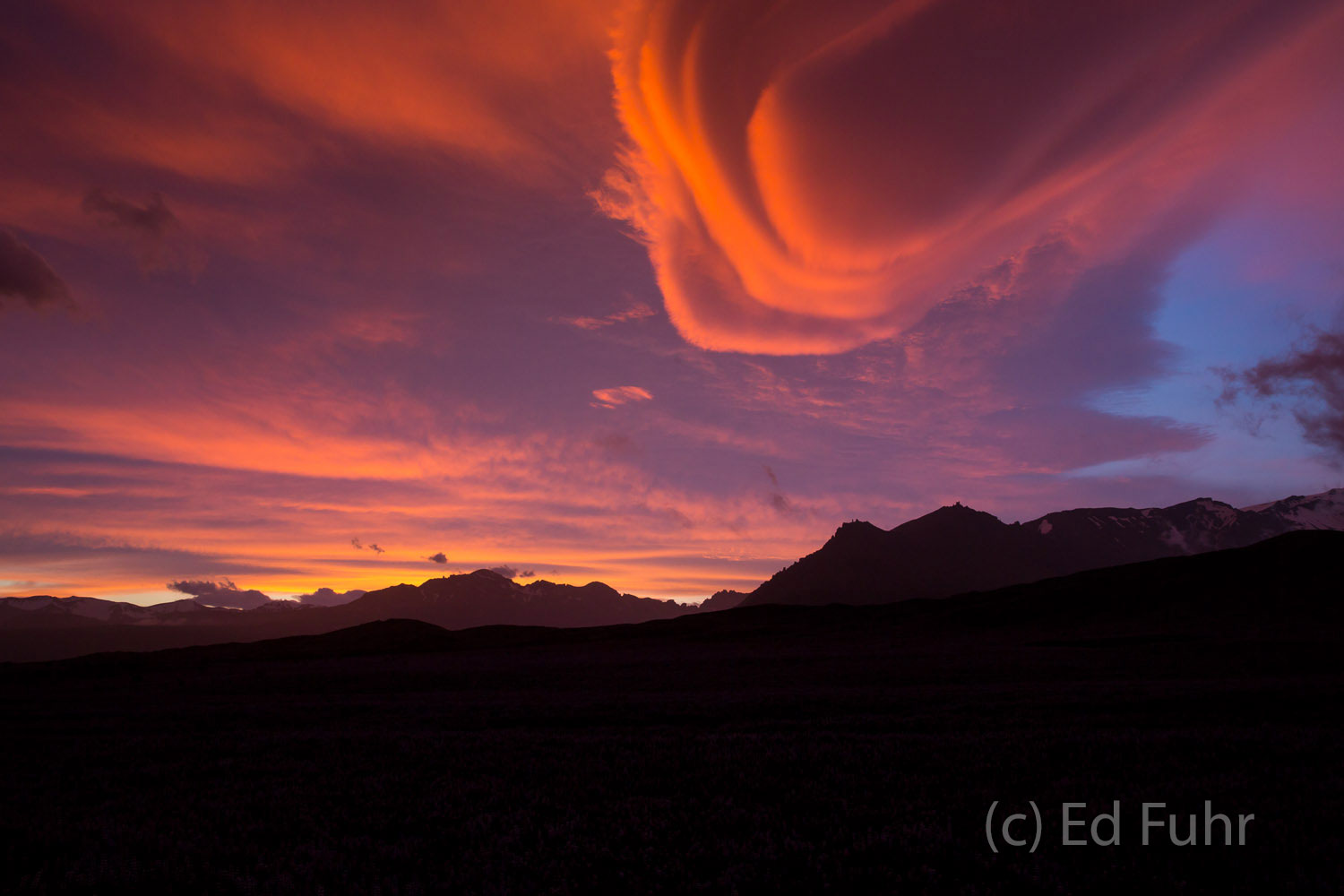 An amazing sunset, strong winds and lenticular clouds above the mountain range give the appearance or an alien invasion.