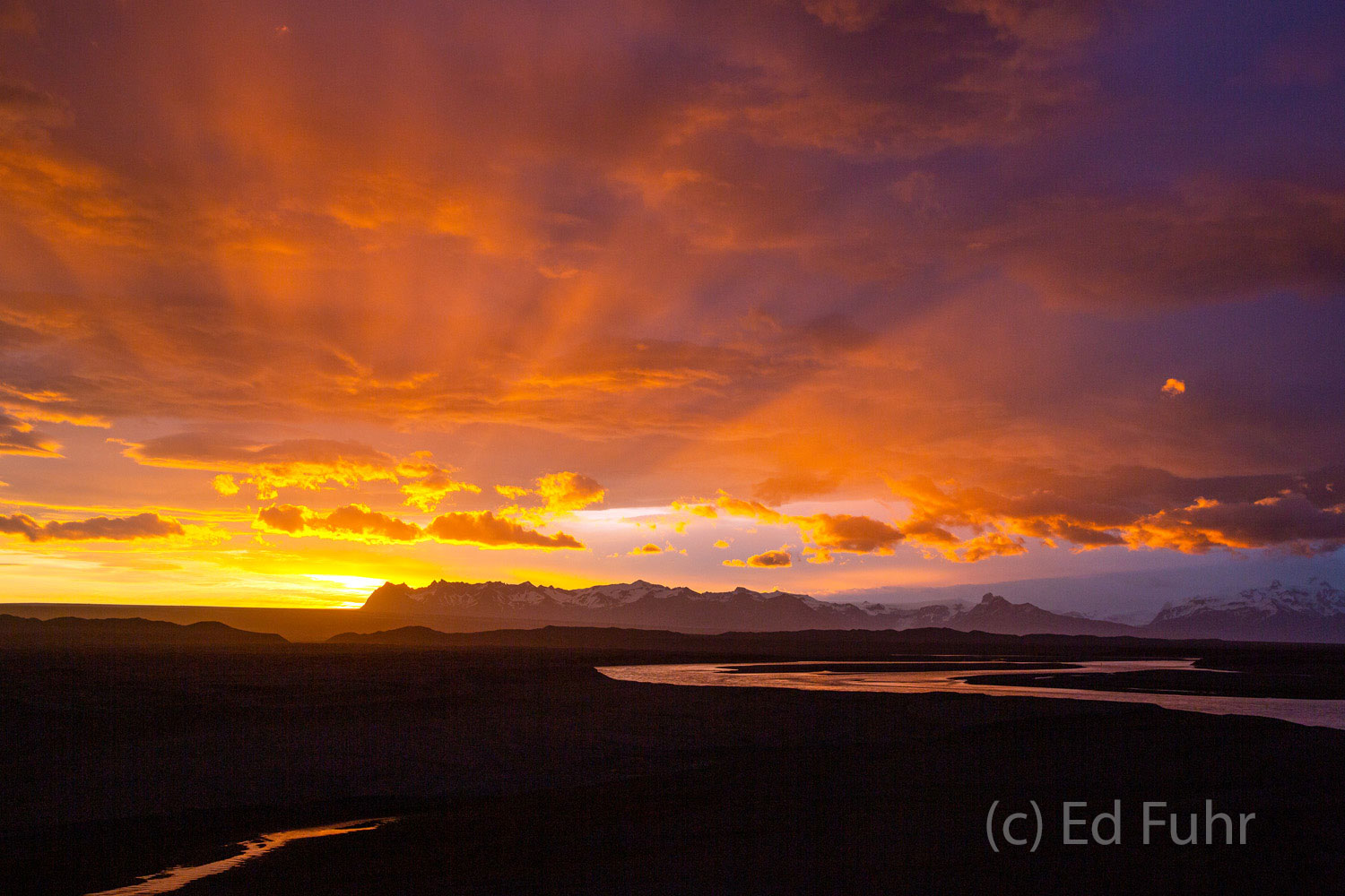 Iceland Sunrise In midsummer, sunrises and sunsets last hours. Here a 3:00 a.m. spectacular sunrise bursts on the Iceland horizon.