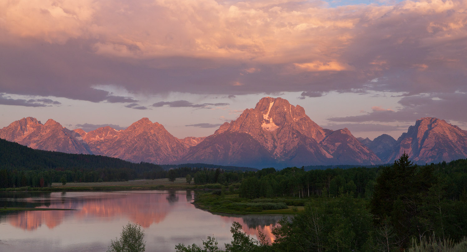 For a few minutes at dawn a warm light bathes Mt. Moran and the Snake River at Oxbow Bend.&nbsp;