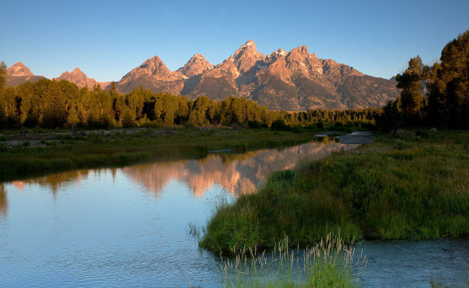 Sunrise touches the Grand Tetons above Schwabacher's Landing.&nbsp;