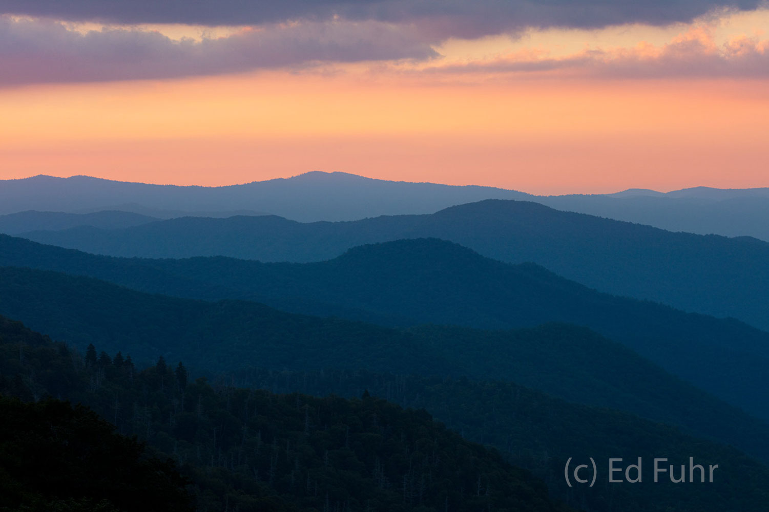 Mountain ridges recede below dusk's final curtain call.