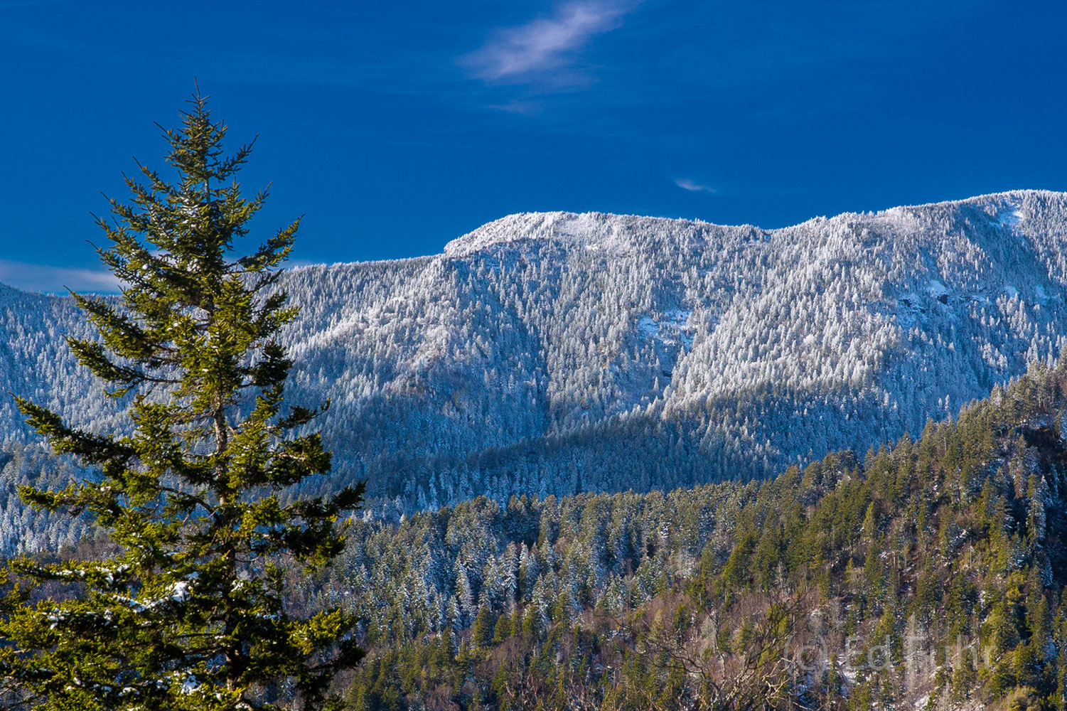 A high mountain ridge is coated in snow in late April.