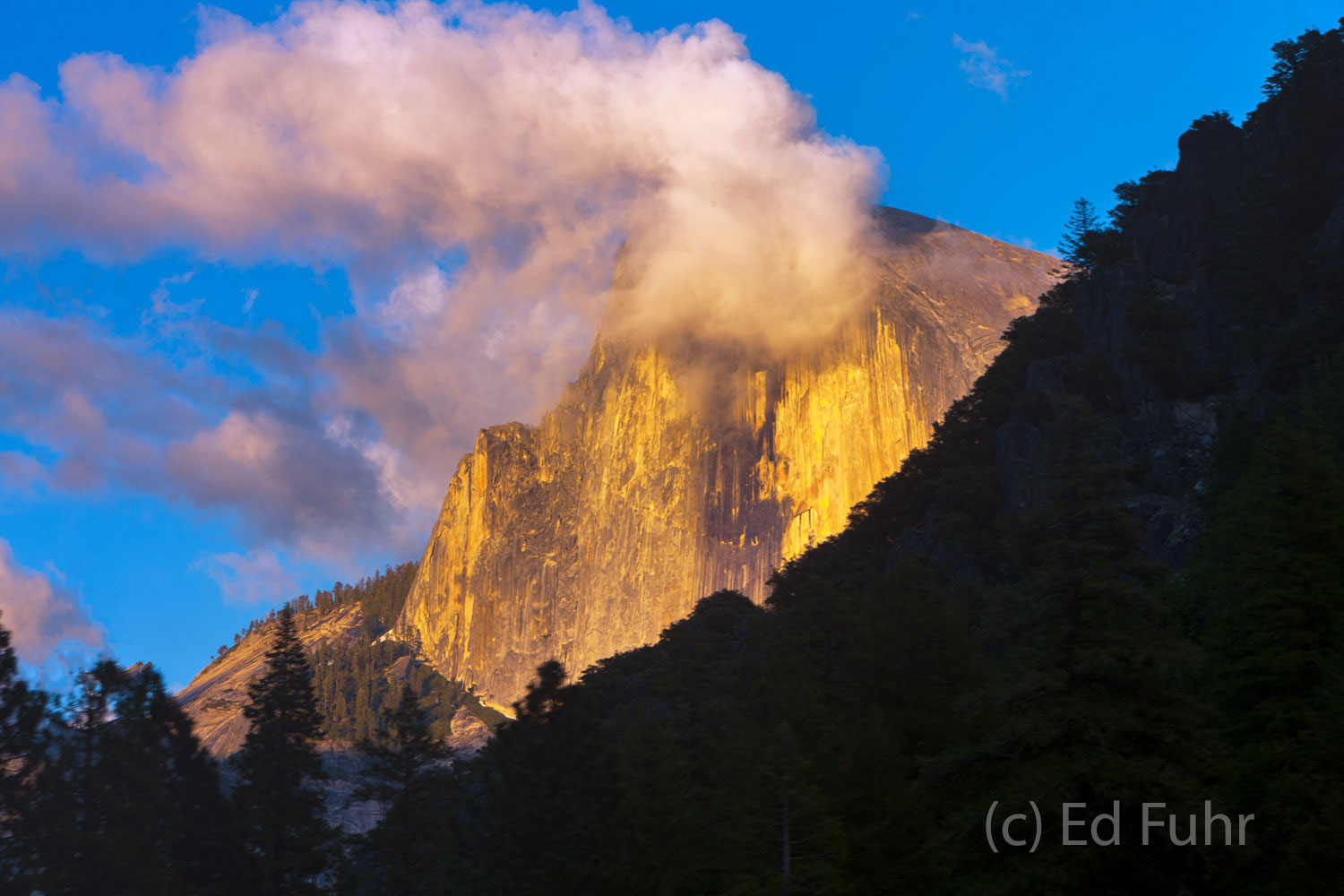 Behind a silhouetted ridge, Half Dome captures the last rays of light. 