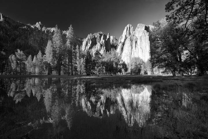 Cathedral Rocks is reflected at sunrise in flooded El Capitan Meadow